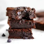 Stack of fudgy protein brownies with melty dark chocolate chips