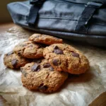Chewy protein cookies with chocolate chunks beside a gym bag