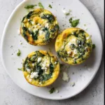 Spinach & Feta Egg Muffins – Meal Prep Snack with Mediterranean Flair 5 Overhead shot of spinach feta egg muffins on a plate with visible herbs and cheese