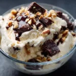 Cottage cheese ice cream with chocolate and nuts in a glass bowl
