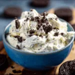 Blue bowl of protein Oreo fluff topped with cookie crumbs