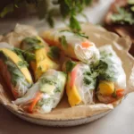 vegetarian rice paper rolls with vermicelli noodles, mango, avocado, and cilantro on a ceramic plate