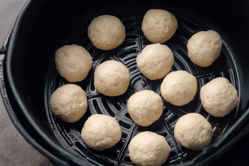 Crispy Protein Donut Holes Air Fryer – Just 3 Ingredients 9 Raw protein donut hole dough arranged in air fryer basket before cooking