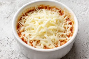 2-Ingredient Cottage Cheese Pizza Bowl (High-Protein, 5-Minute Lunch!) 11 unbaked cottage cheese pizza bowl topped with shredded mozzarella cheese