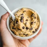 2-Ingredient Almond Chickpea Cookie Dough (High-Protein & No Bake) 7 hand holding bowl of almond chickpea cookie dough with chocolate chips