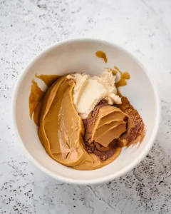 Bowl with peanut butter, protein powder, and honey before mixing for no bake cookies