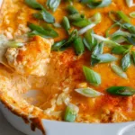 side view of cottage cheese buffalo chicken dip with carrots and pita on wooden board