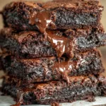 Stack of fudgy Greek yogurt brownies with melted chocolate