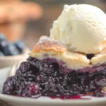 5-Ingredient Keto Blueberry Pie (Crispy Crust, Gooey Center!) 8 Keto blueberry pie slice with melting vanilla ice cream on rustic table