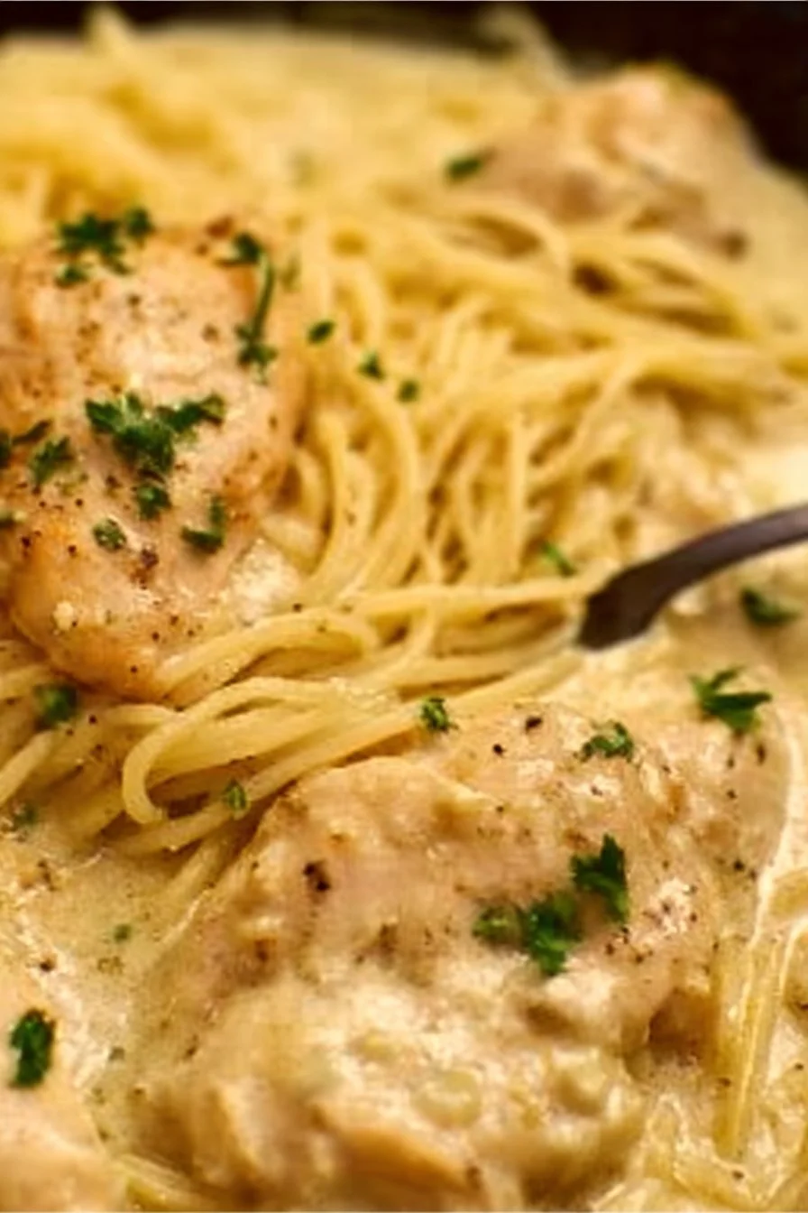 Crock Pot Angel Chicken served with creamy sauce and herbs on a plate