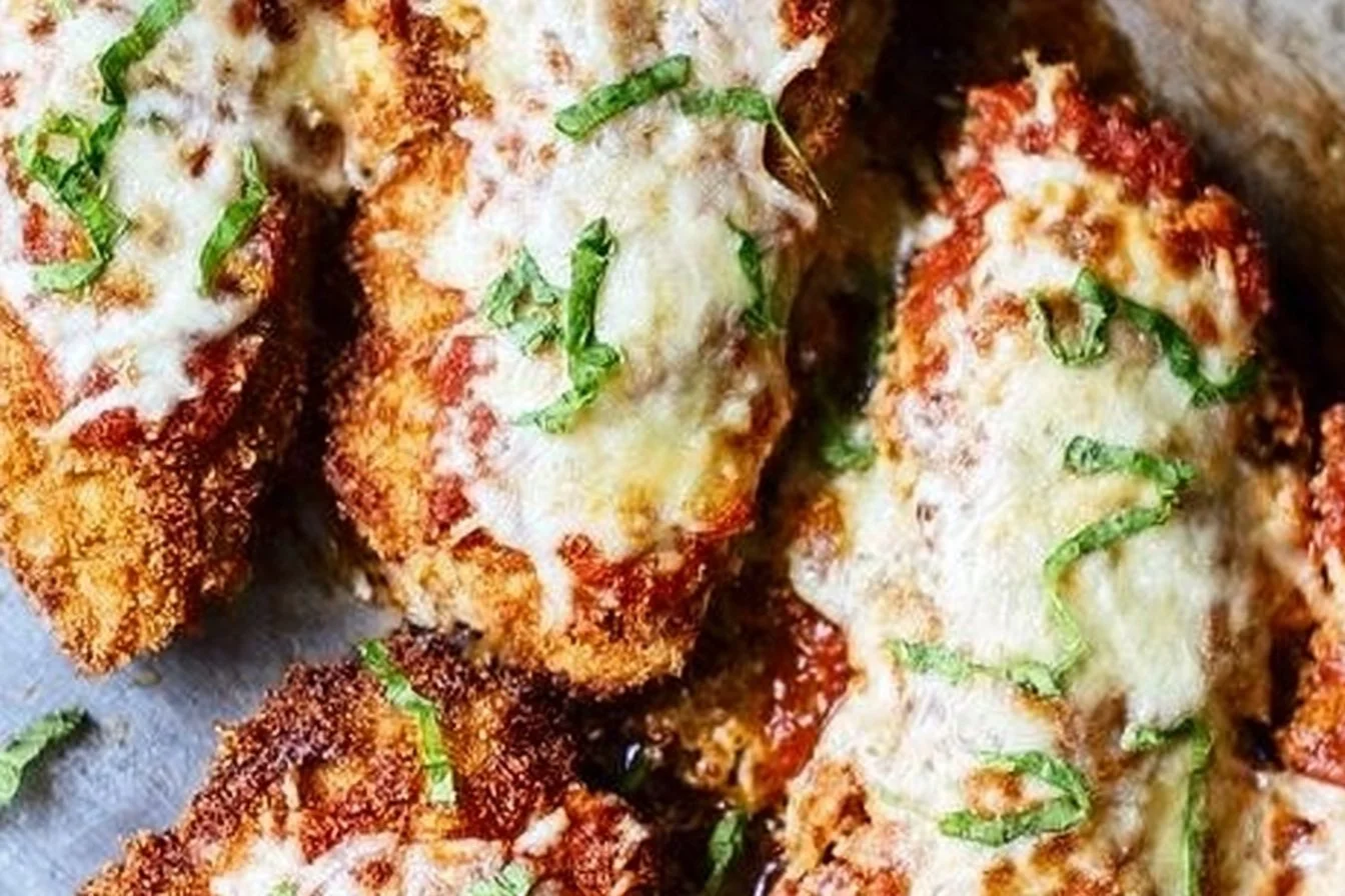 Crispy Chicken Parmesan 4 Crispy Chicken Parmesan topped with marinara sauce and cheese on a plate