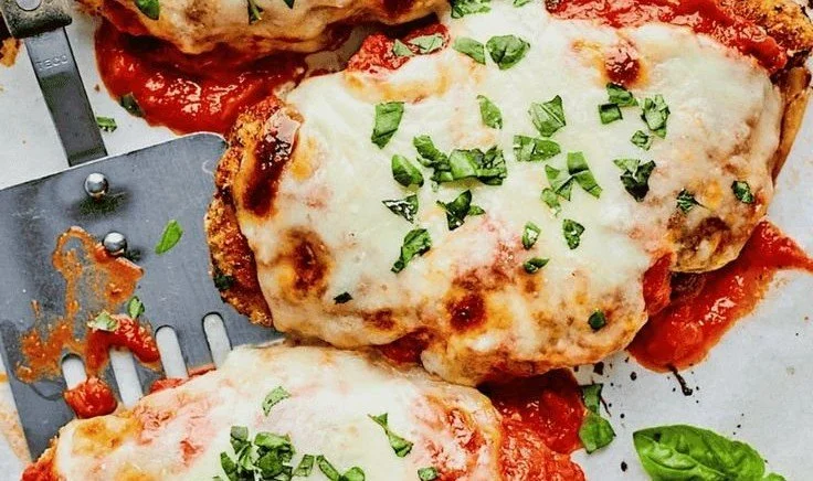 Ina Garten's Chicken Parmesan 4 Delicious plate of Ina Garten's Chicken Parmesan garnished with fresh basil.